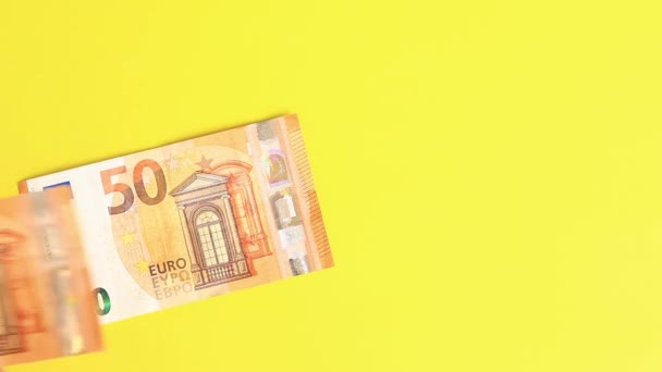 Proveď výpočty. Rozložte bankovky po padesáti eur na žlutém pozadí. Vkládat peníze do jasného pozadí. Pojem investice, podnikání, směnárna nebo výplata - Záběry, video