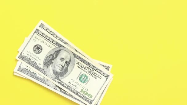 計算をする. 100ドル紙幣を黄色の背景に置くこと. 明るい背景でお金を稼ぐこと. 投資,ビジネス,マネー交換,支払いの概念 - 映像、動画