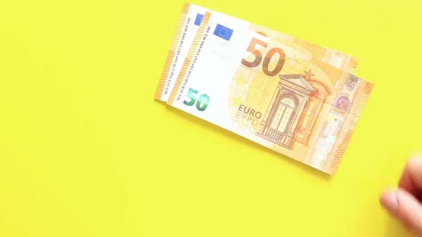 Proveď výpočty. Rozložte bankovky po padesáti eur na žlutém pozadí. Vkládat peníze do jasného pozadí. Pojem investice, podnikání, směnárna nebo výplata - Záběry, video