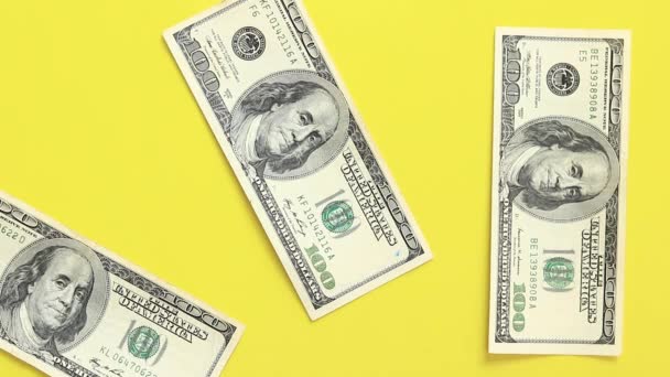 Proveď výpočty. Položte stodolarové bankovky na žluté pozadí. Vkládat peníze do jasného pozadí. Pojem investice, podnikání, směnárna nebo výplata - Záběry, video
