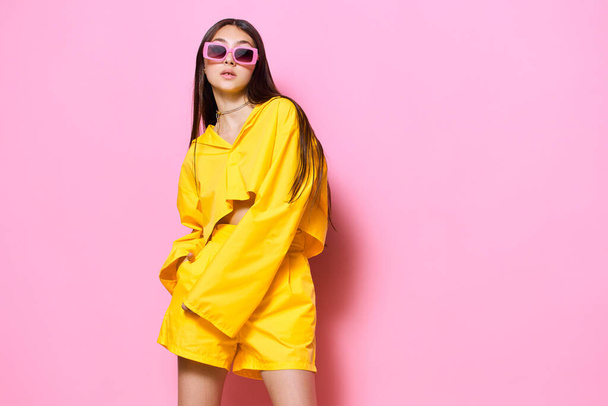 розовая женщина летом желтые привлекательные солнцезащитные очки образ жизни девушка прическа студия модель романтический стиль портрет наряд модный креативный мода веселая красивая молодая - Фото, изображение
