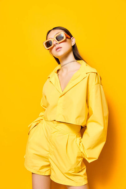 ντύσιμο γυναίκα μονόχρωμη μοντέρνο στυλ μόδας στούντιο ειδύλλιο ευτυχισμένη γυαλιά ηλίου ελκυστικό lifestyle φόντο δημιουργική όμορφη νεαρή όμορφη κίτρινο κορίτσι όμορφο πρόσωπο - Φωτογραφία, εικόνα