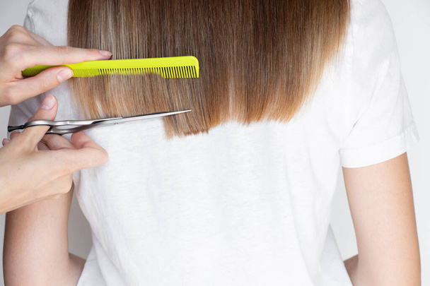Жіночі руки вирізали дівчачі волосся ножицями, стрижкою та перукарнею - Фото, зображення