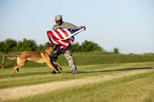 Heróis de guerra e verdadeiros patriotas desfrutando de liberdade e independência. Soldado e cão de trabalho militar segurando bandeira dos EUA. - Foto, Imagem