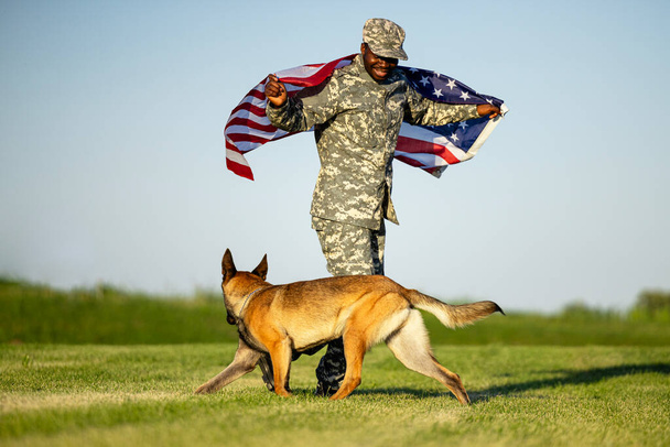 Герої війни. Солдат у формі і його військовий супутник собаки святкування патріотизму. - Фото, зображення