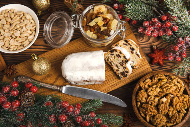 Christmas stollen on wooden background. Traditional Christmas festive pastry dessert. Holiday concept. Dessert, cake, pie with marzipan, nuts and dried fruits. Stollen for Christmas. Spicy pastries. - Foto, Bild