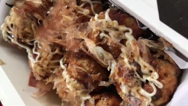 Köstliche Takoyaki-Köstlichkeiten: Nahaufnahme über traditionelles japanisches Street Food mit pikanten Soßen, cremiger Mayonnaise und tanzenden Bonito-Flocken (Katsuobushi-Flocken)) - Filmmaterial, Video