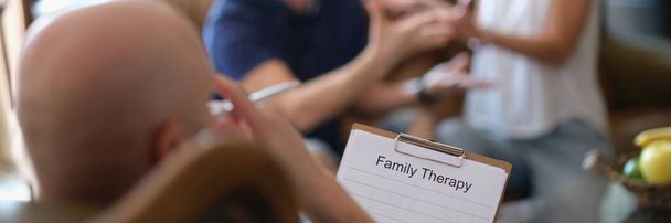 Clipboard with text family therapy and blurred married couple and psychologist. Solving family problems and psychological counseling. - Foto, Imagem