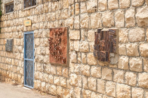 Haifa, Israele, 03 giugno 2023: Muro di pietra decorato con prodotti di artisti locali nel famoso villaggio di artisti Ein Hod vicino a Haifa nel nord di Israele - Foto, immagini