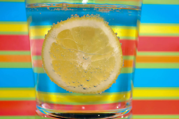 Limonade sprudelnd Getränk in einem klaren Glas mit buntem Hintergrund zeigt sprudelnde Blasen gut für Ihre Multimedia-Content-Erstellung Hintergrund - Foto, Bild
