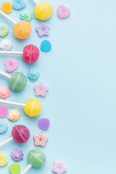 Красочные сладкие леденцы и конфеты на голубом фоне. Плоский, вид сверху - Фото, изображение
