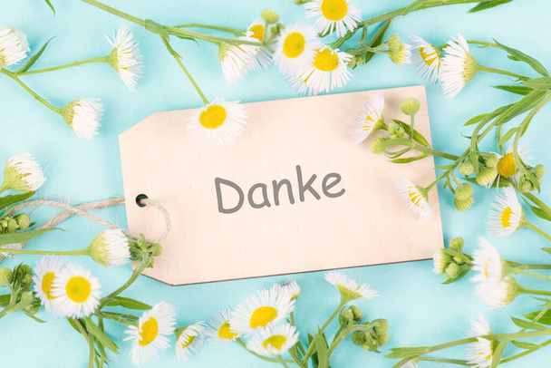 Thanks card surrounded by flowers, german language, being thankful, support, help and charity concept, positive attitude  - Photo, Image