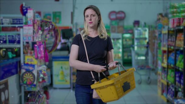 Серьёзная белая женщина в супермаркете в трудные времена, привычки к потребительскому образу жизни - Фото, изображение