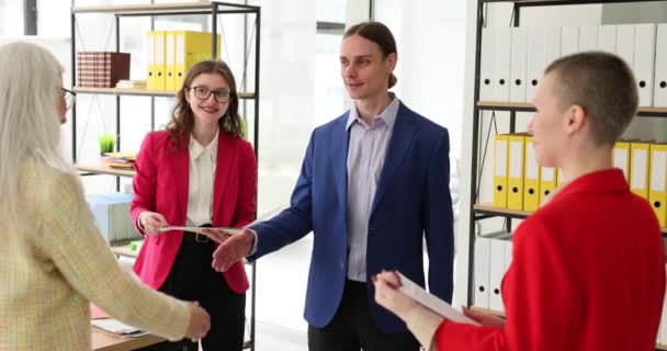 Happy confident senior business woman, business leader trainer getting acquainted with new team of employees. Interns and students shaking hands with employee at informal meeting - Footage, Video