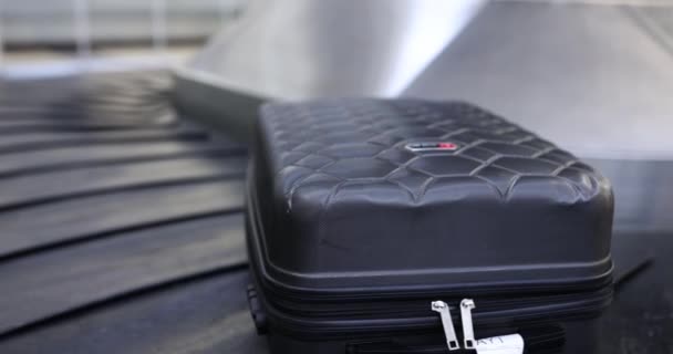 Один чемодан лежит на багажной карусели в зале прибытия аэропорта. Концепция получения или потери багажа - Кадры, видео