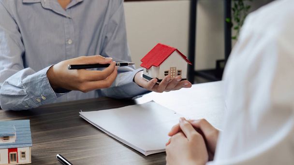 Immobilienmakler und Bauherr sprechen vor Vertragsunterzeichnung über Immobilienversicherung und Sicherheitskonzept für Haus zu Bauherr.. - Foto, Bild