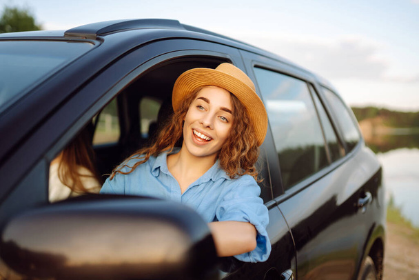 Portrait of two young women on a car trip having fun, smiling, chatting together, enjoying nature. Active lifestyle, travel, tourism, nature. - Foto, afbeelding