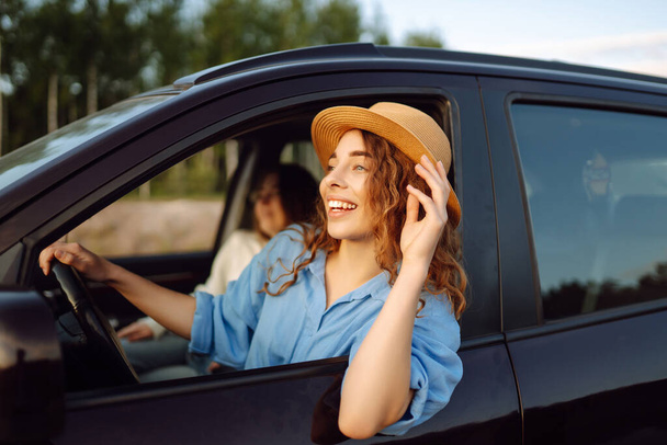 Portrait of two young women on a car trip having fun, smiling, chatting together, enjoying nature. Active lifestyle, travel, tourism, nature. - Foto, Bild