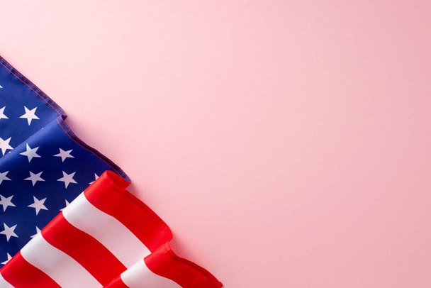 Conmemorando el trabajo de las mujeres en el Día del Trabajo. Vista superior de un fondo rosa aislado con una bandera americana que ofrece espacio para mensajes de texto o promocionales - Foto, Imagen