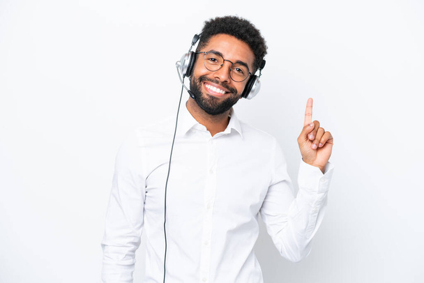Telemarketer Brazilian man working with a headset isolated on white background showing and lifting a finger in sign of the best - Fotoğraf, Görsel