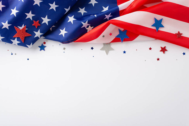 Feiertagsstimmung: Eine stimmungsvolle Komposition über dem Kopf mit den Konfettisternen der amerikanischen Flagge auf weißem Hintergrund. Ideal für Werbung oder Textplatzierung während der Veranstaltung - Foto, Bild