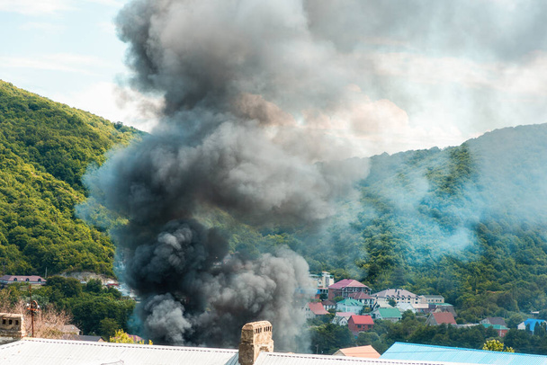 ファイアー。 燃えている建物の上の灰色の煙の雲の近く. 緊急・災害・保険事故のコンセプト. - 写真・画像
