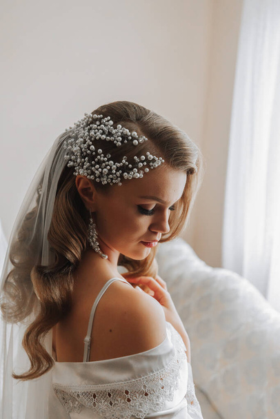 portrait of an elegant girl with long hair and a tiara on her head preparing for a wedding ceremony - Фото, изображение