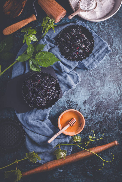 Amoras-pretas orgânicas em formas de cozimento, amoras maduras com ingredientes de cozimento e untensil de cozinha - Foto, Imagem