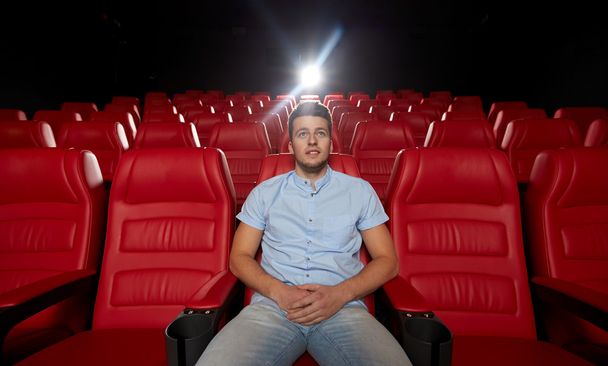 młody mężczyzna oglądanie filmu w teatrze - Zdjęcie, obraz