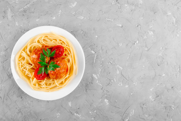 Massa com um delicioso emparelhamento de almôndegas de estilo siciliano em molho de tomate em fundo de gesso cinza - Foto, Imagem