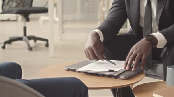 Gehakt van Afro-Amerikaanse zakenman lezen contract en schudden de hand aan zijn partner het sluiten van een succesvolle deal tijdens de vergadering in functie - Video