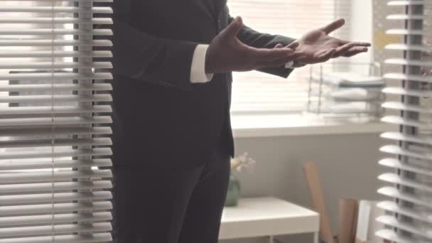 Cultivado de dos hombres de negocios afroamericanos en trajes gesticulantes mientras hablan y se dan la mano después de concluir el trato - Metraje, vídeo