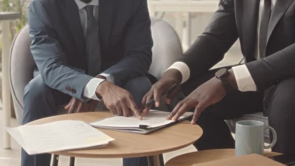 Cultivado de dos hombres de negocios seguros en trajes que concluyen contrato y estrechando la mano durante la reunión en la oficina - Metraje, vídeo