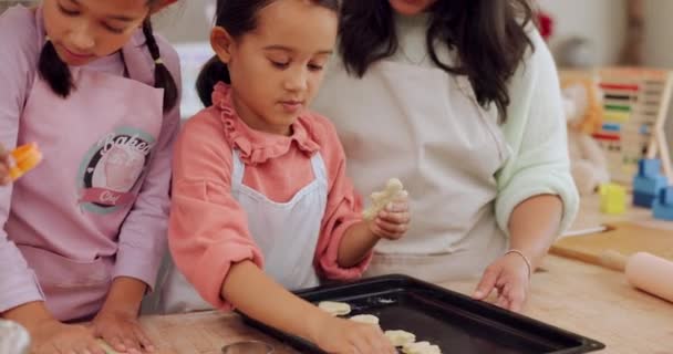 Oma, Mutter und Kinder lernen gemeinsam in der heimischen Küche das Backen, um als Fertigkeit oder Pflege das Dessert zuzubereiten. Familie, Mutter und Mädchen, die Kinder mit einem Plätzchenrezept oder Essen unterrichten oder ihnen helfen. - Filmmaterial, Video