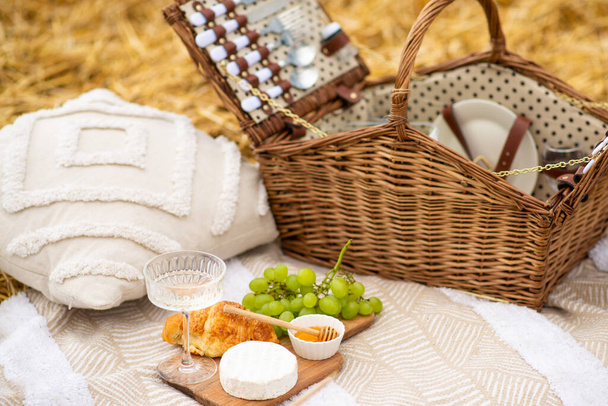 picnic. picnic basket on the field. leisure and drinks concept - close up of food, drinks and basket on picnic blanket on grass - Photo, Image