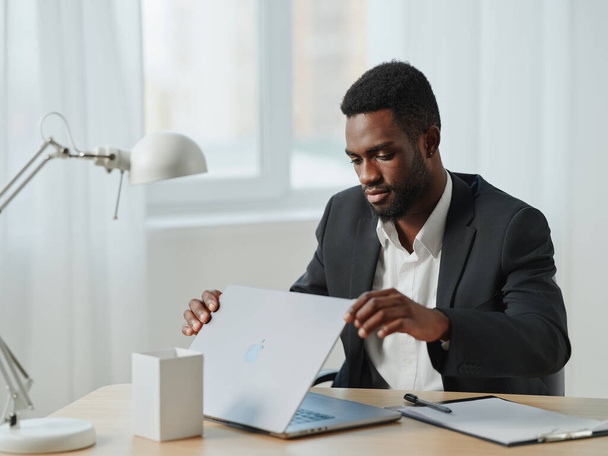 сидящий мужчина американская работа бизнесмен фрилансер компьютерный офис студент африканский ноутбук корпоративный дом в Интернете с помощью настольного образования современная карьера черный - Фото, изображение