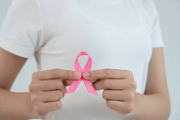Woman hold pink ribbon breast cancer awareness. Female health check consciousness. international Women Day and World Cancer Day. sign cancer, Symbolic, health care, support patients, timely diagnosis - Photo, image