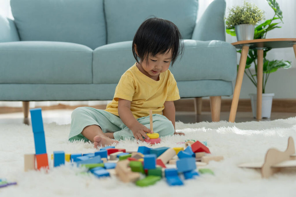 Feliz niño asiático jugando y aprendiendo bloques de juguetes. los niños están muy contentos y emocionados en casa. niño pasar un buen rato jugando, actividades, desarrollo, trastorno por déficit de atención con hiperactividad - Foto, Imagen