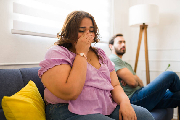 Сумна товста жінка плаче і виглядає засмученою після бою зі своїм хлопцем і має проблеми з відносинами - Фото, зображення