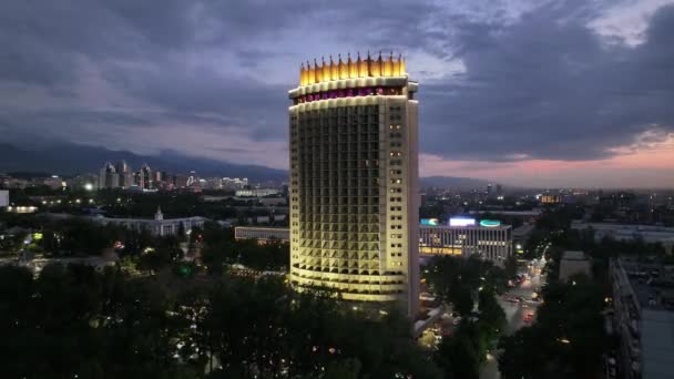 Вид с квадрокоптера на центральную часть города Алматы в летние вечерние сумерки - Кадры, видео