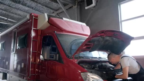 A car mechanic is repairing a truck. The concept of maintenance and repair of cars. - Imágenes, Vídeo