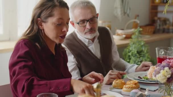 家でイースターの日にお祝いの夕食を食べながら食べ物を共有する大規模なコーカサス家族のパンショット - 映像、動画