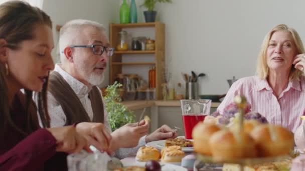Senior pár chatování s dcerou při jídle sváteční večeře během velikonoční rodinné oslavy doma - Záběry, video