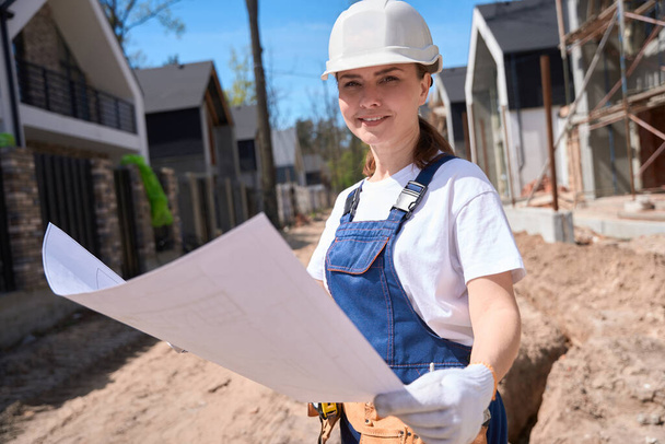 Woman general contractor studying drawings of buildings to know how to start construction correctly, architect contemplating about landscape design - Фото, изображение