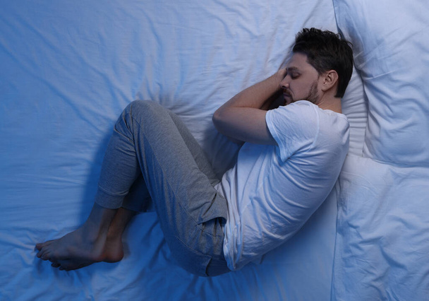 Man sleeping in bed at night, top view - Foto, Imagen