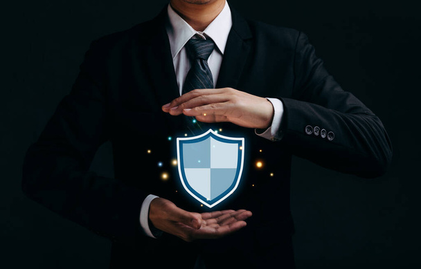 Концепція кібербезпеки та захисту мережі, Бізнесмен тримає значок захисту щита. - Фото, зображення