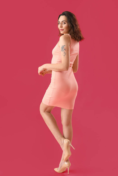 Attractive young woman in dress on pink background - Foto, Bild