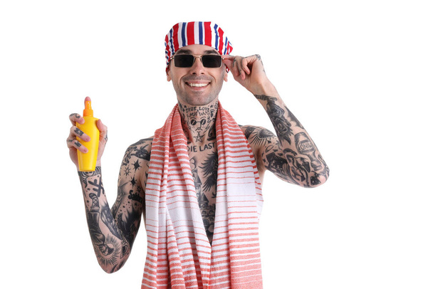 Hombre tatuado con crema protector solar sobre fondo blanco - Foto, imagen
