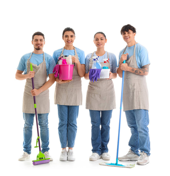Young janitors with cleaning supplies on white background - Photo, Image