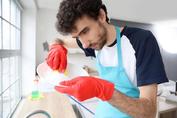 Fiatal férfi mosogatás a konyhában, közelkép - Fotó, kép